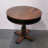 A rosewood veneered circular revolving occasional table, A/F and repairs to veneer, H. 74cm Dia.