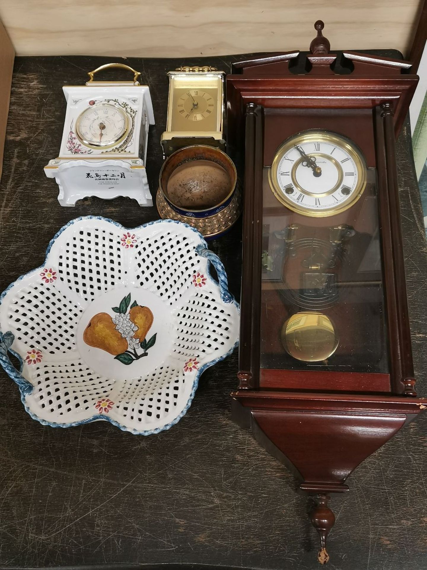 A wall clock, a porcelain mantel clock and three other items.