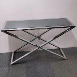 A mirror topped and metal crossed base side table, 120 x 79 x 40cm.