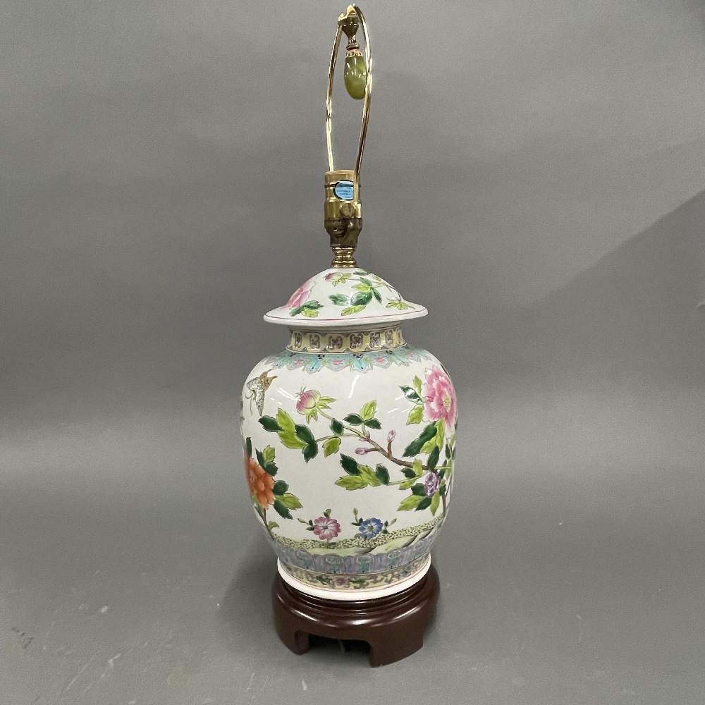 A Chinese hand painted porcelain jar and cover mounted as a lamp base on a wooden stand, H. 55cm.