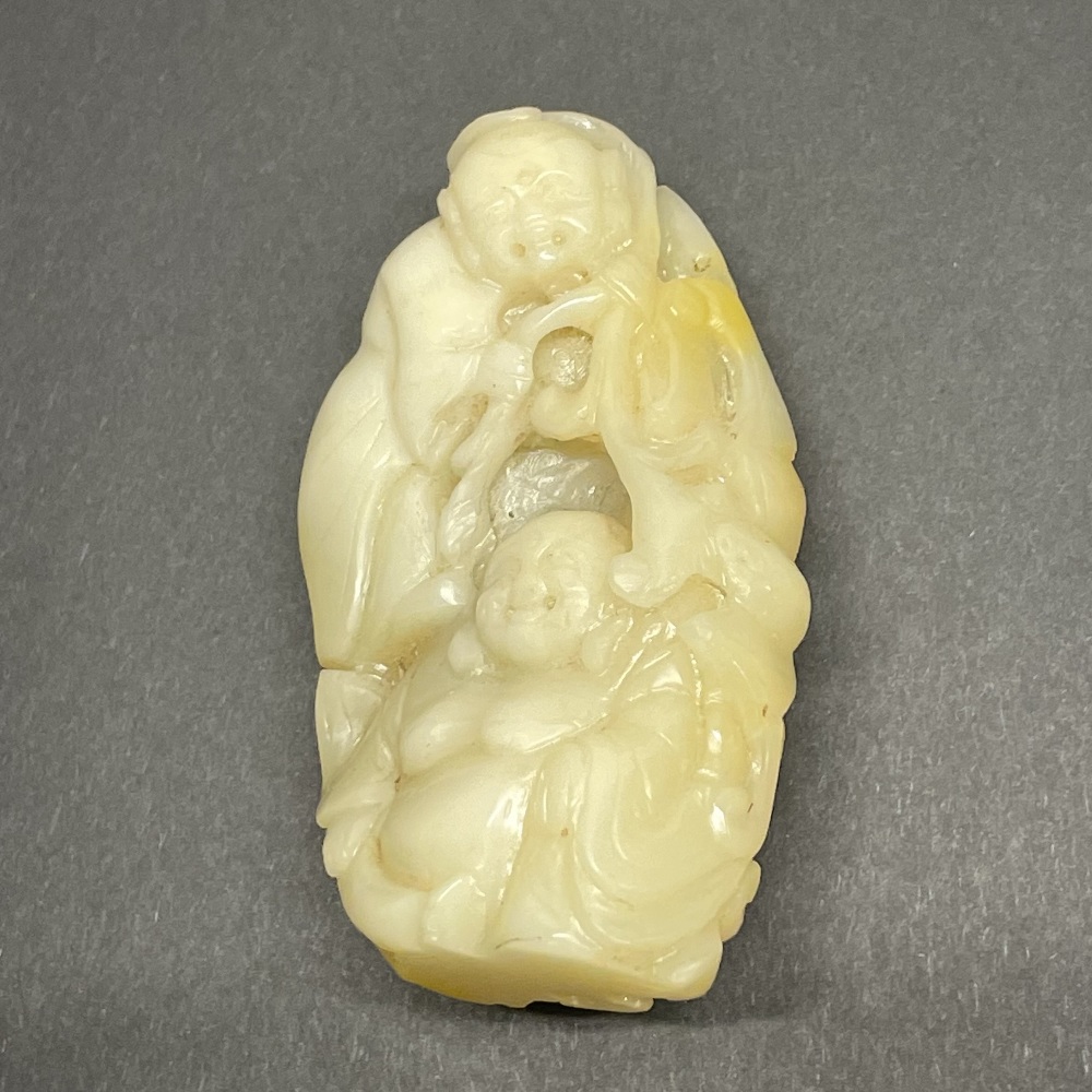 An early 20th century Chinese mutton fat jade figure of the seated Buddha with an acolyte, H. 8.
