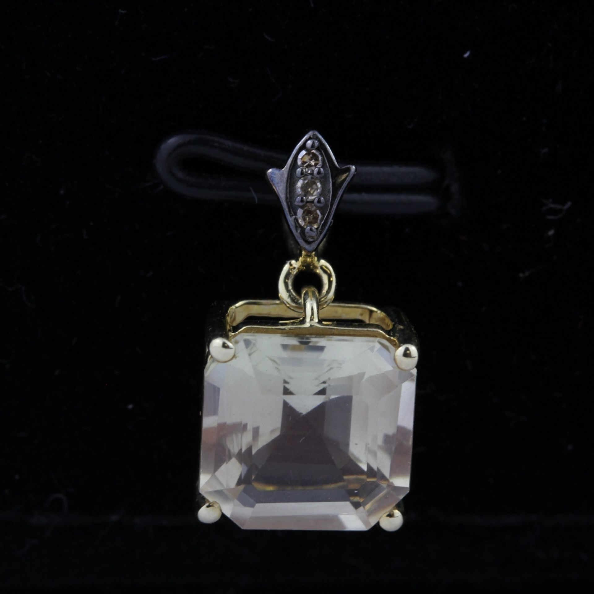 A 10ct yellow gold (stamped 10K) pendant set with an emerald cut lemon quartz and diamonds, L. 1.