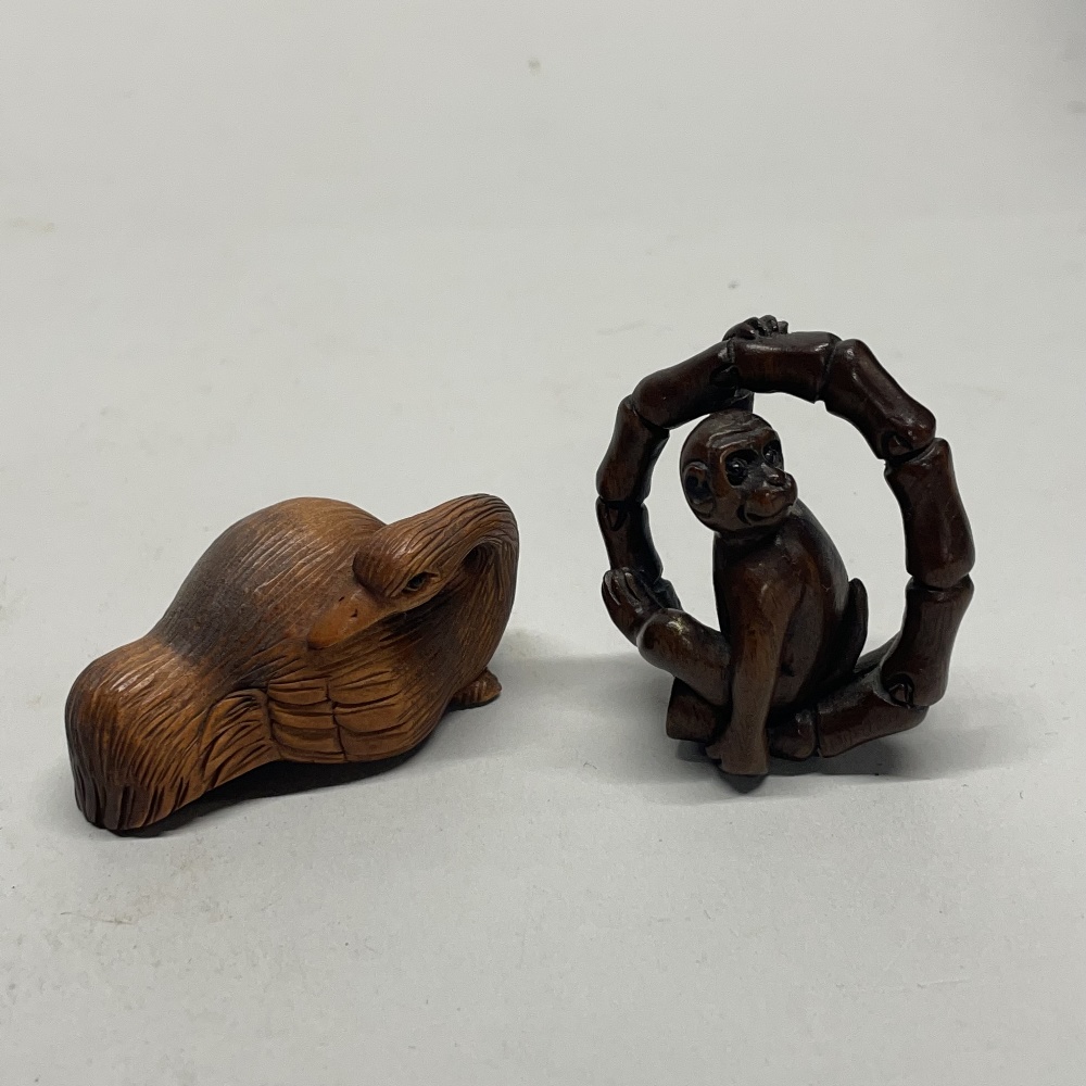A Chinese craved wooden netsuke of a resting crane, together with a further carved wooden netsuke of