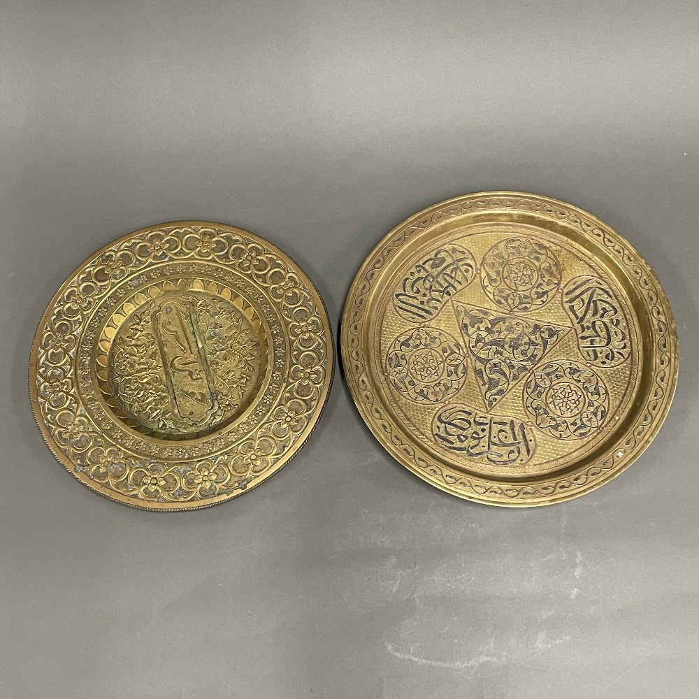 Two 19th / early 20th century Eastern hammered brass trays, one with silver and copper decoration,