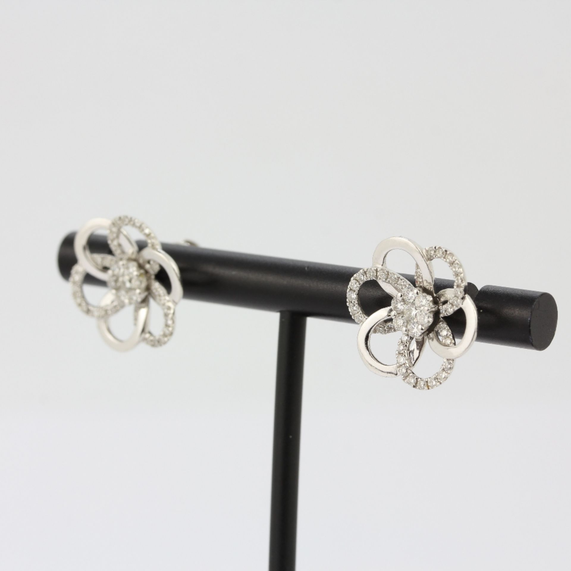 A pair of 18ct white gold flower shaped stud earrings set with brilliant cut diamonds, L. 1.6cm. - Image 3 of 4