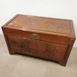 An oriental carved hardwood blanket box with brass decoration and hinges, some stains to top, 105