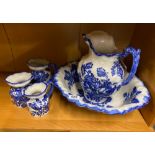 A porcelain wash bowl and jug with three graduated jugs.