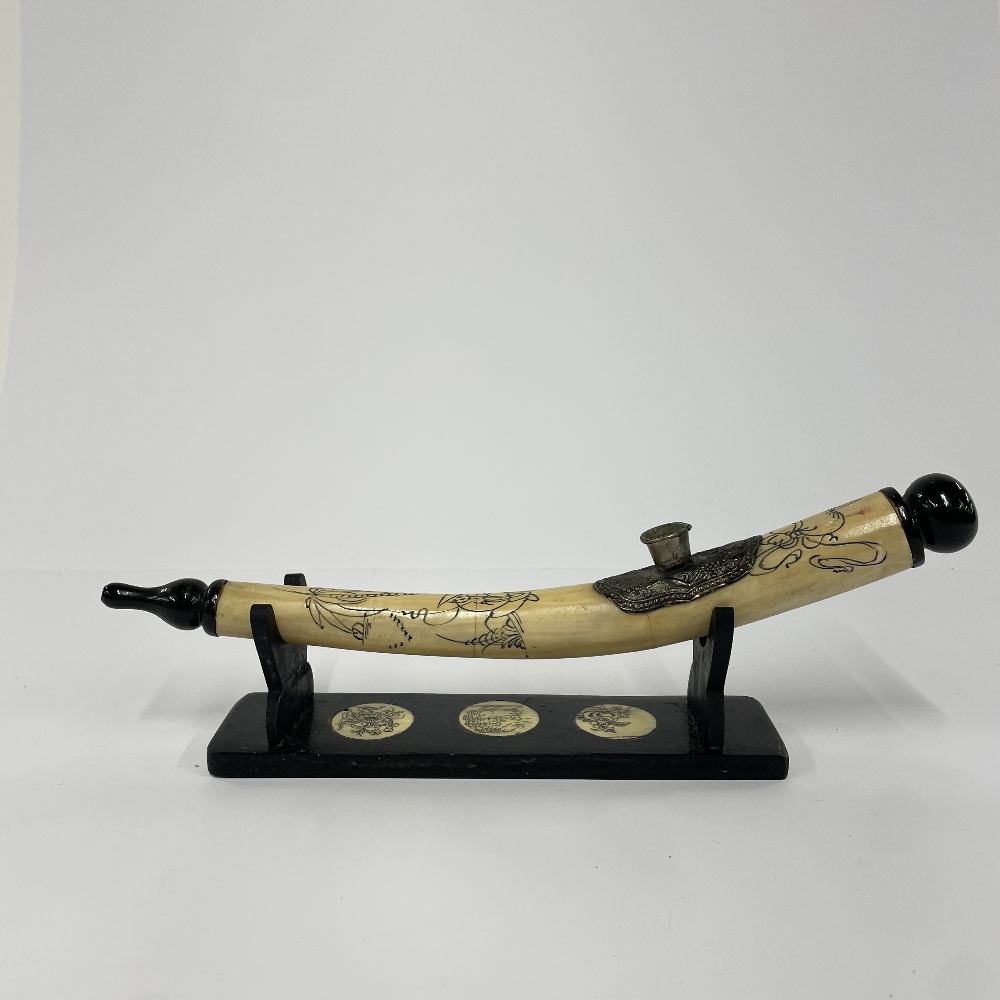 An Oriental bone opium pipe with stand, L. 30cm.