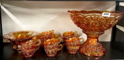 A carnival glass punch bowl with cups and other items.