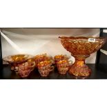 A carnival glass punch bowl with cups and other items.