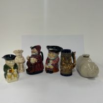 Four cermaic character jugs, a German stein and a stoneware hot water bottle, tallest H. 20cm.