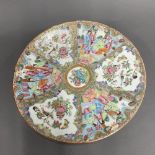 A 19th century Chinese famille rose enamelled and gilt plate, Dia. 35cm, with 19th century staple