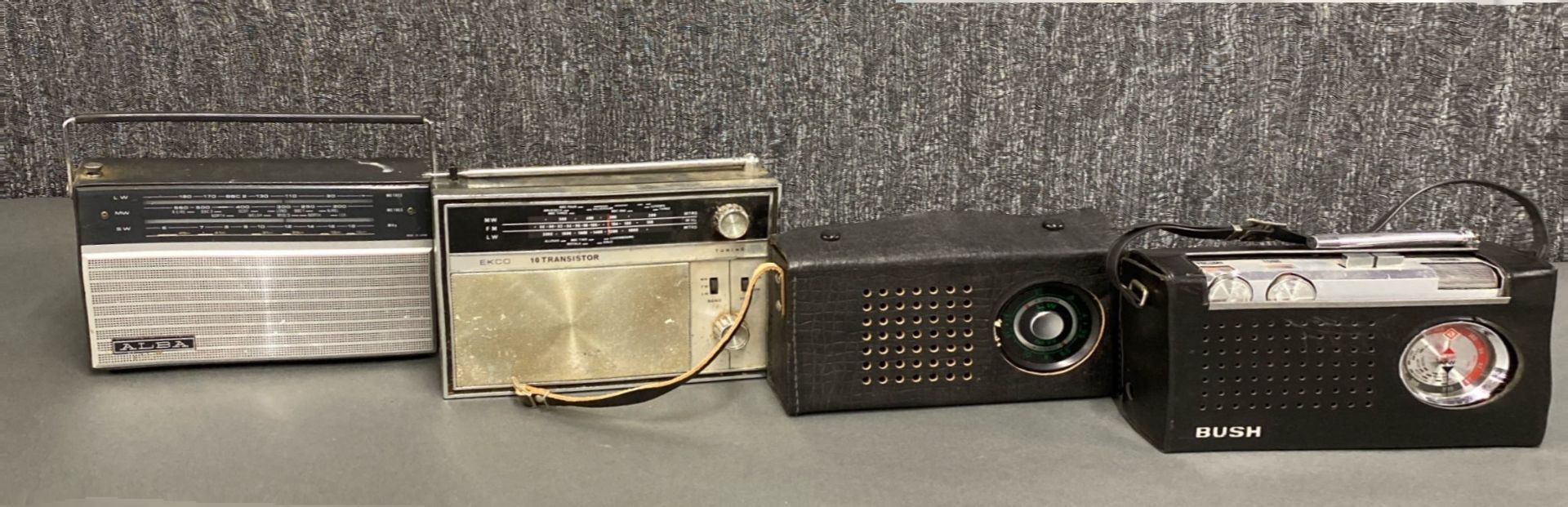 A group of four solid state transistor radios including Bush, Alba , Ekco PT306 and Vega.