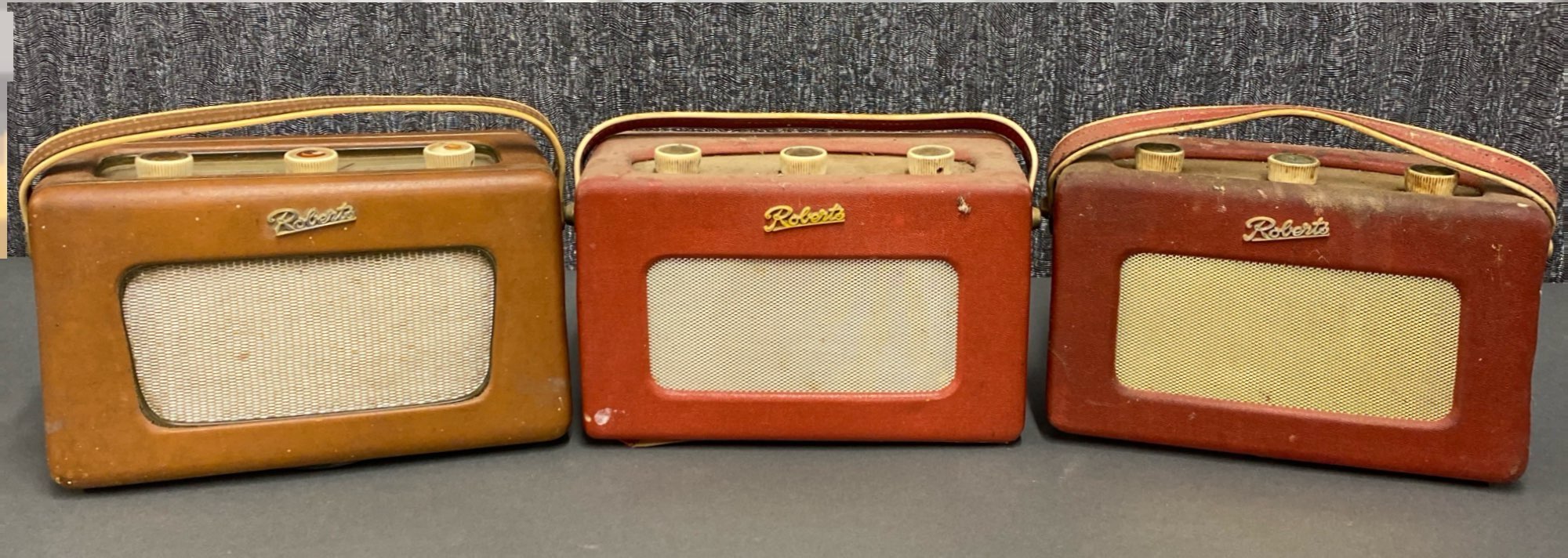 A group of three early Roberts transistor radios, including two R200 and one R300.