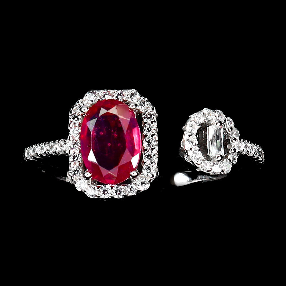 A 925 silver ring set with an oval cut ruby and white stones, ring size N.