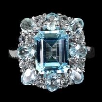 A 925 silver ring set with an emerald cut blue topaz and round cut blue topaz, ring size O.