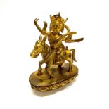 A Tibetan gilt bronze figure of Buddhist deity riding a pony H. 23cm