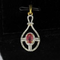 A 9ct yellow gold pendant set with an oval cut ruby and diamonds, L. 3cm.