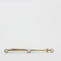 A yellow metal (tested minimum 9ct gold) diamond set bar brooch, estimated approx. 0.50ct total,
