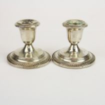 A pair of weighted sterling silver candle sticks, H. 8cm.