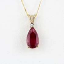 A 10ct yellow gold pendant set with a large pear cut ruby and a diamond on a 10ct gold chain, ruby