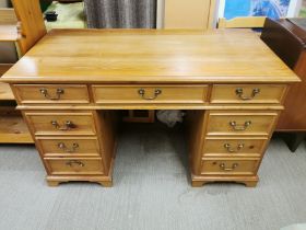 A seven drawer kneehole pine writing desk, 128 x 78 x 65cm.