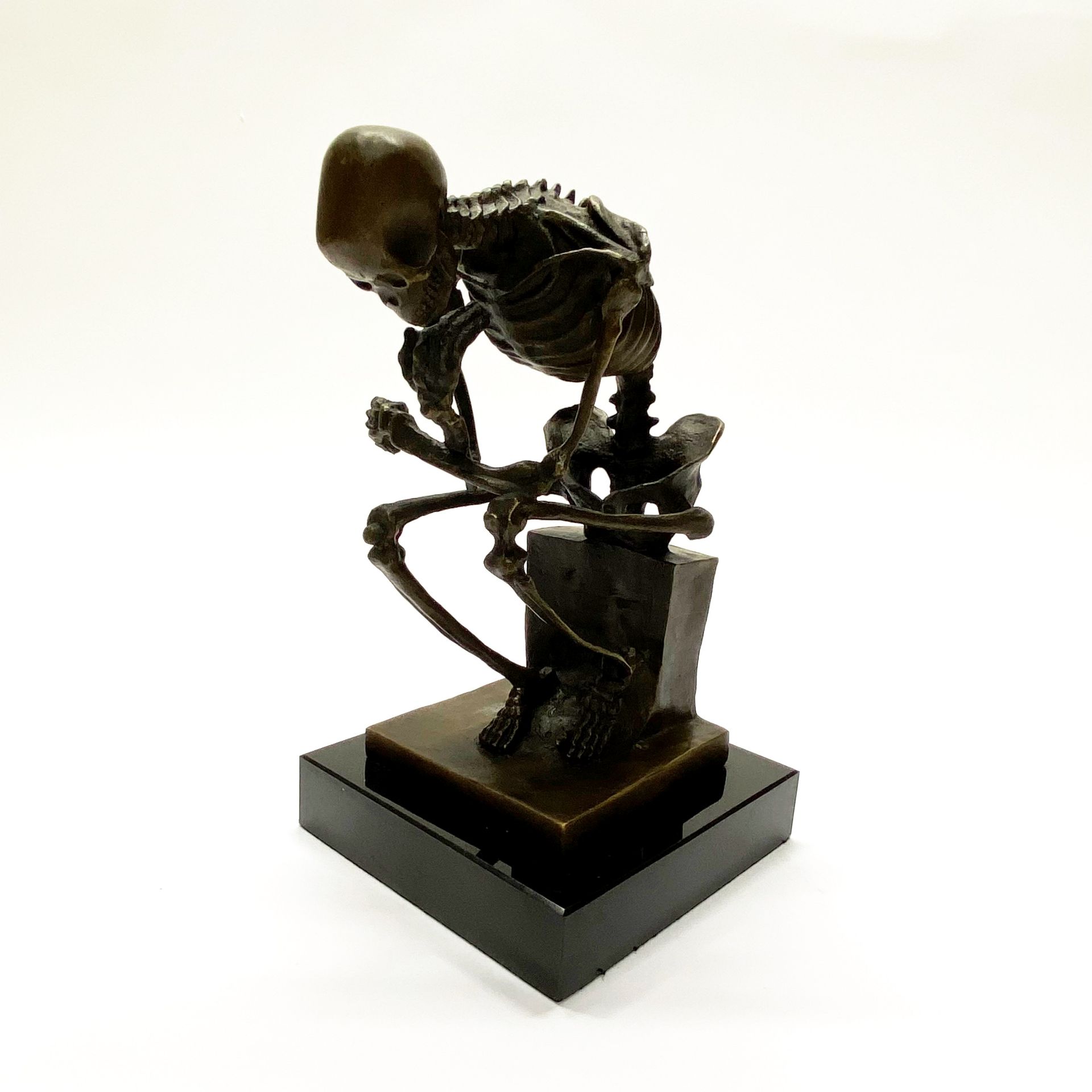 An interesting cast bronze skeleton on black marble base. H. 23cm