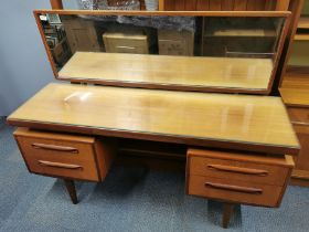 A mid 20thC teak G-Plan 'Fresco range' dressing table and mirror with plate glass top and middle