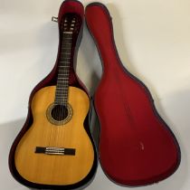 A cased Kimbara acoustic guitar.