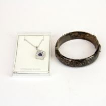 A vintage silver hinged bangle with a silver pendant and chain.