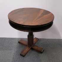 A rosewood veneered circular revolving occasional table, A/F and repairs to veneer, H. 74cm Dia.