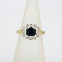 A hallmarked 9ct yellow gold ring set with a cushion cut 'teal' sapphire surrounded by diamonds, (