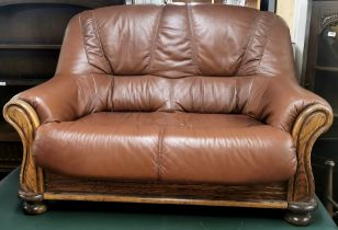 A leather and oak two seater settee/ sofa, H. 95cm W. 140cm.