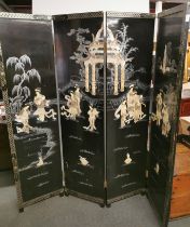 A Chinese four panel black lacquer and mother of pearl folding screen with relief chinoiserie