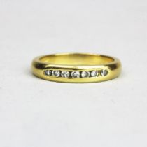 An 18ct yellow gold (tested) diamond set half eternity ring, (N).