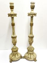 A pair of 18thC Italian painted and gilt wooden candlesticks H. 70cm.