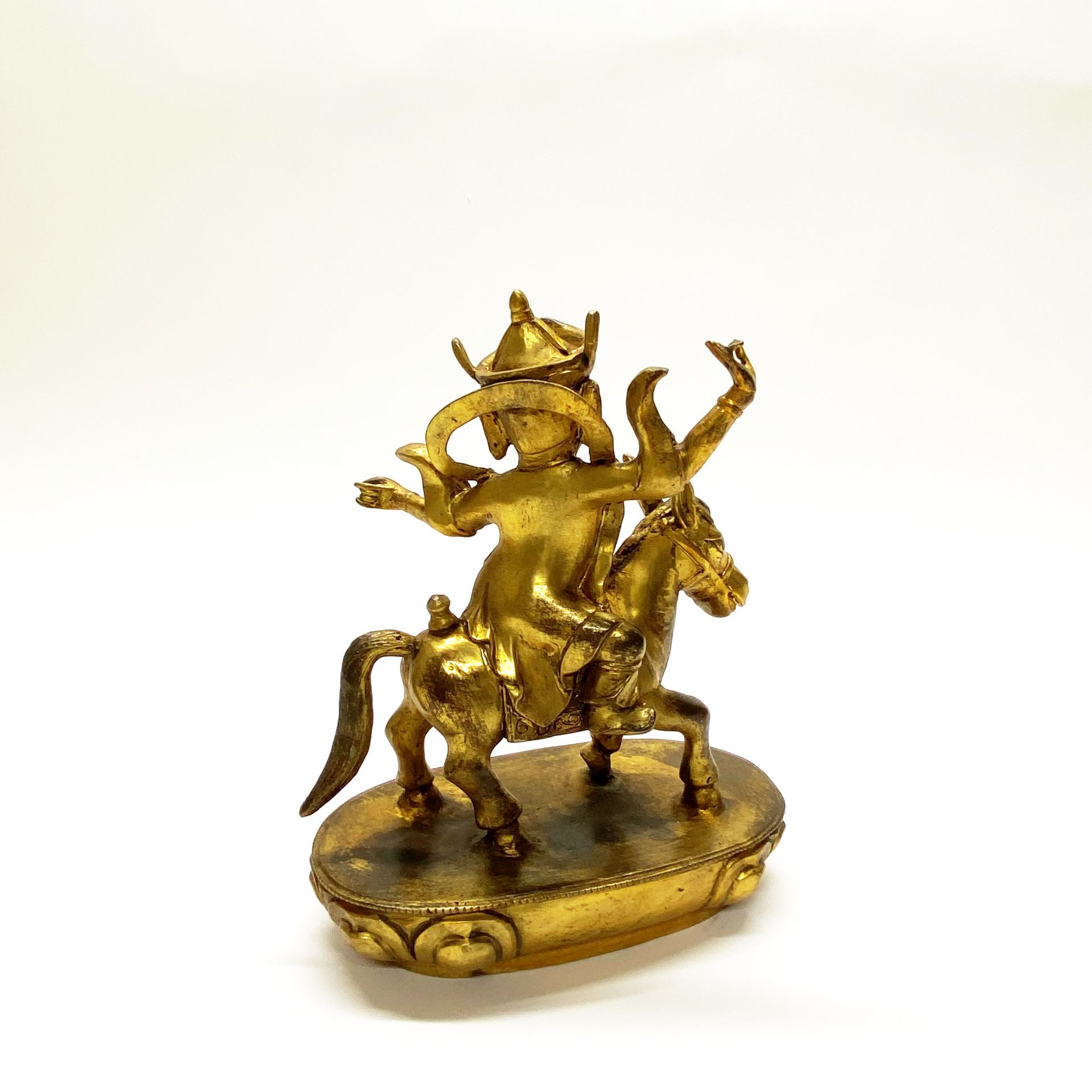 A Tibetan gilt bronze figure of Buddhist deity riding a pony H. 23cm - Image 3 of 3