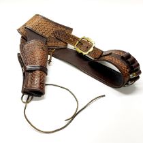 A vintage western leather holster and belt for a peacemaker or similar revolver.