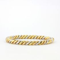 A heavy 18ct yellow and white gold twist design bangle, internal L. 6cm.