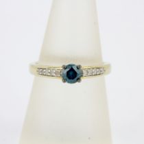 A 10ct yellow gold ring set with a round cut blue diamond and white diamond set shoulders, (O).