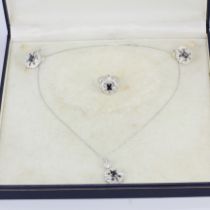 A 14ct white gold jewellery suite comprising of diamond and sapphire earrings, a matching pendant on