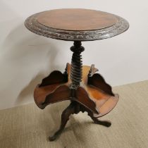 A 19thC carved mahogany circular side table with book stand second tier, H. 77cm Dia. 52cm.
