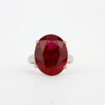 An 18ct white gold solitaire ring set with a large oval cut ruby (not natural), stone L. 1.8cm, (O.