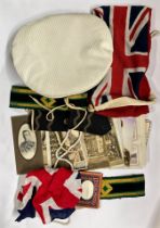 A Naval cap, flag and a group of other items and photographs.