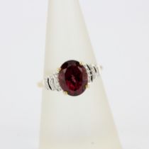 A 14ct yellow gold Art Deco style ring set with an oval cut garnet and diamond shoulders, (O).