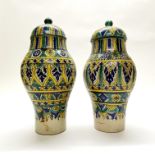 A pair of 19th/early 20thC eastern hand painted pottery jars and lids. H. 39cm (A/F)