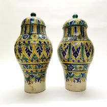 A pair of 19th/early 20thC eastern hand painted pottery jars and lids. H. 39cm (A/F)