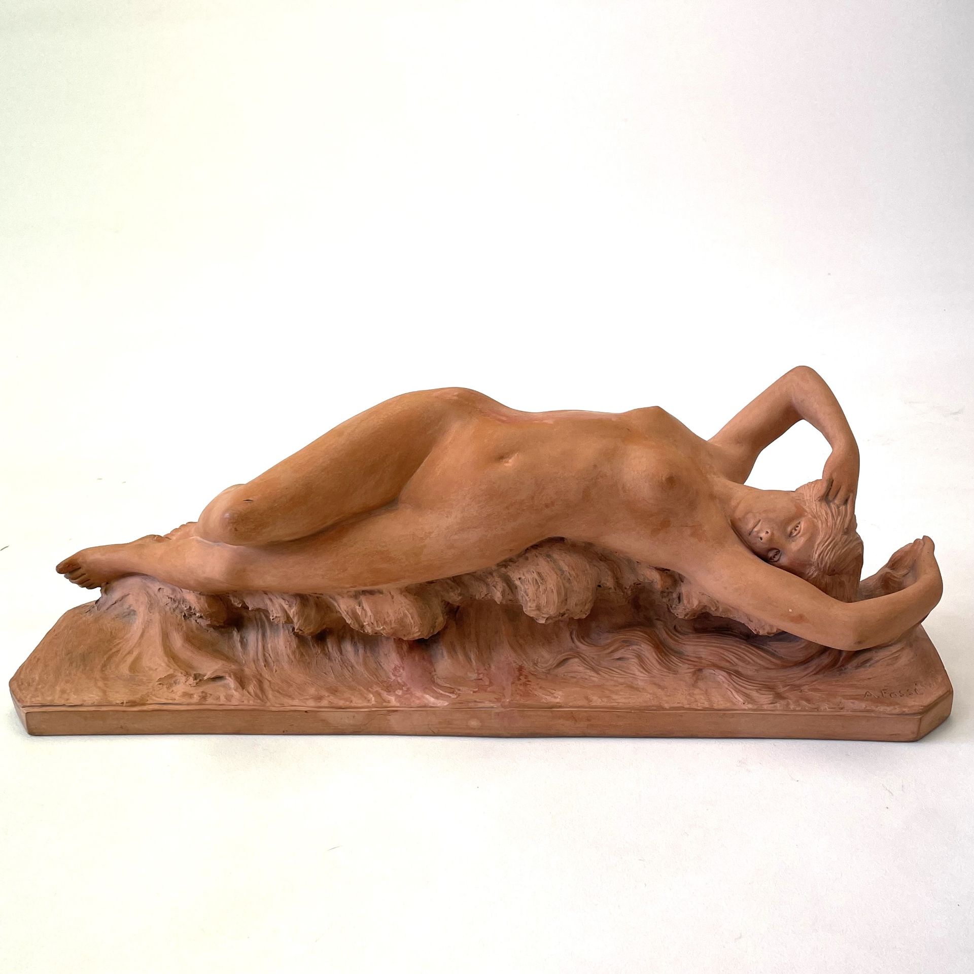 An early 20thC French terracotta sculpture of a naked female figure stamped verso "Terre cuite d'