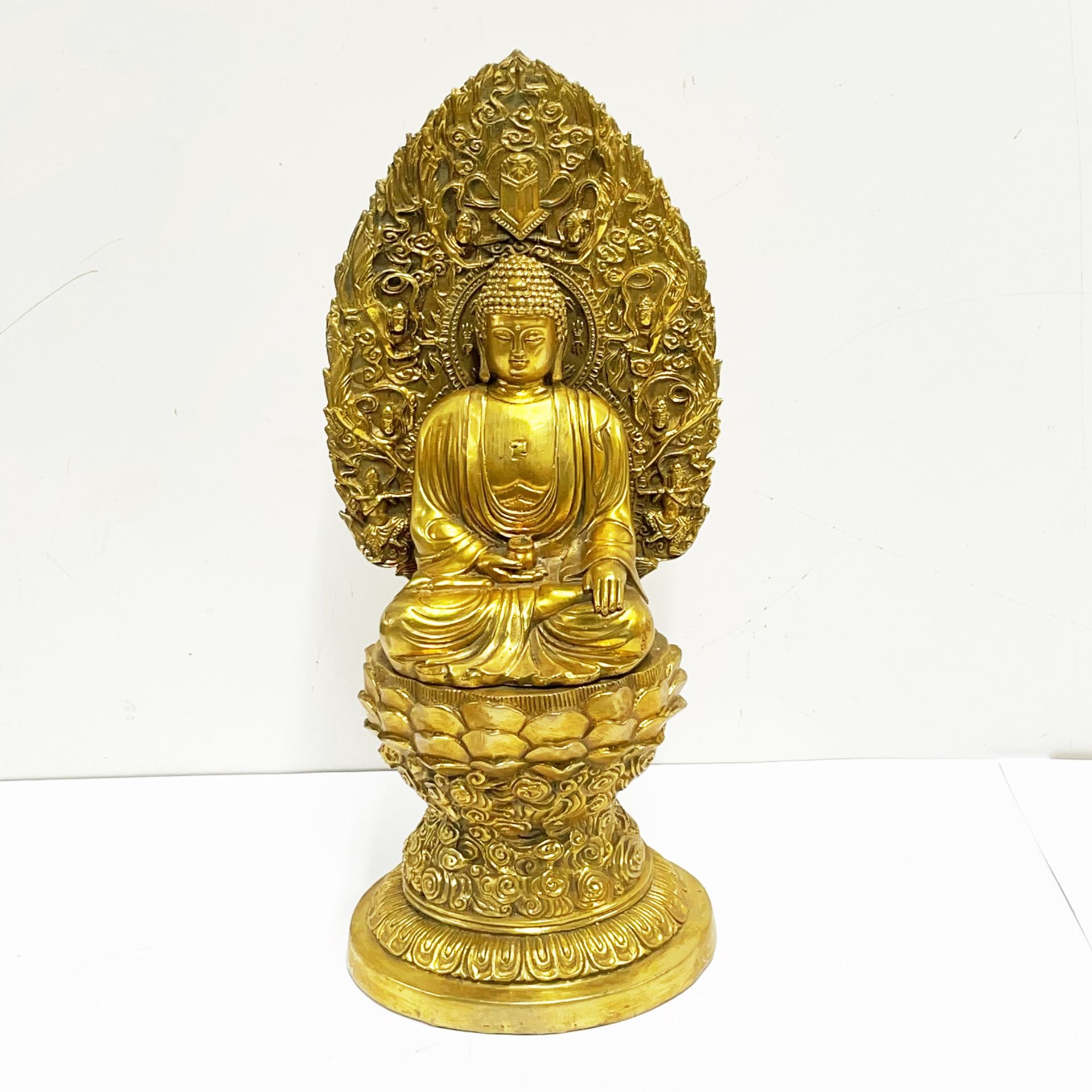 A tibetan gilt bronze figure of a seated Buddha H. 36cm.