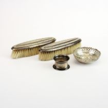 A pair of silver hallmarked backed brushes with a silver dish and napkin ring.